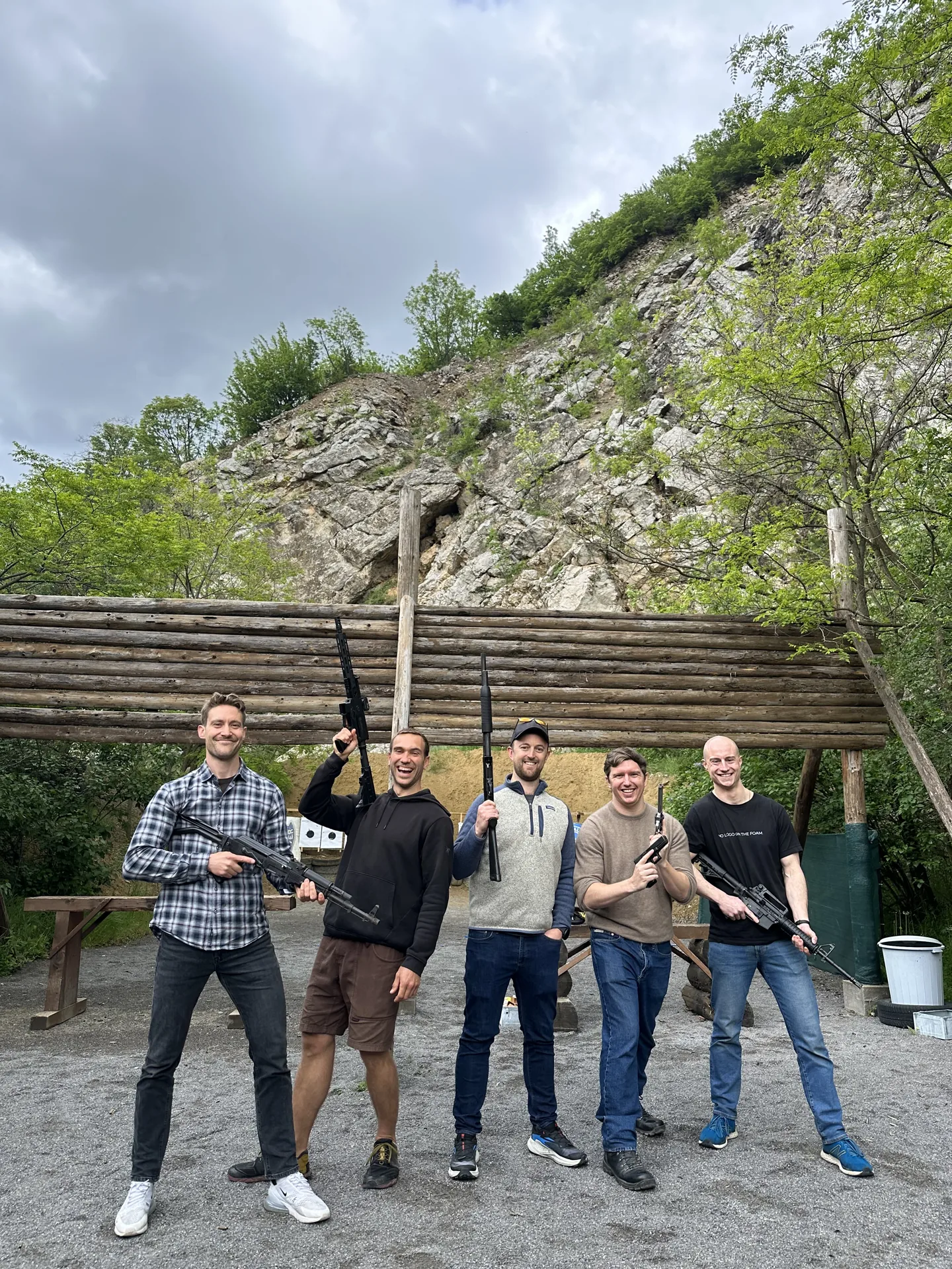 Tourists holding AK-47 and M16 rifles at the shooting lanes of the outdoor gun range near Sofia